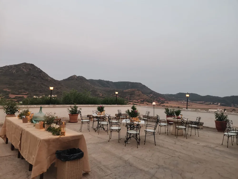 Terraza con mesas y vistas al campo de Menorca al atardecer